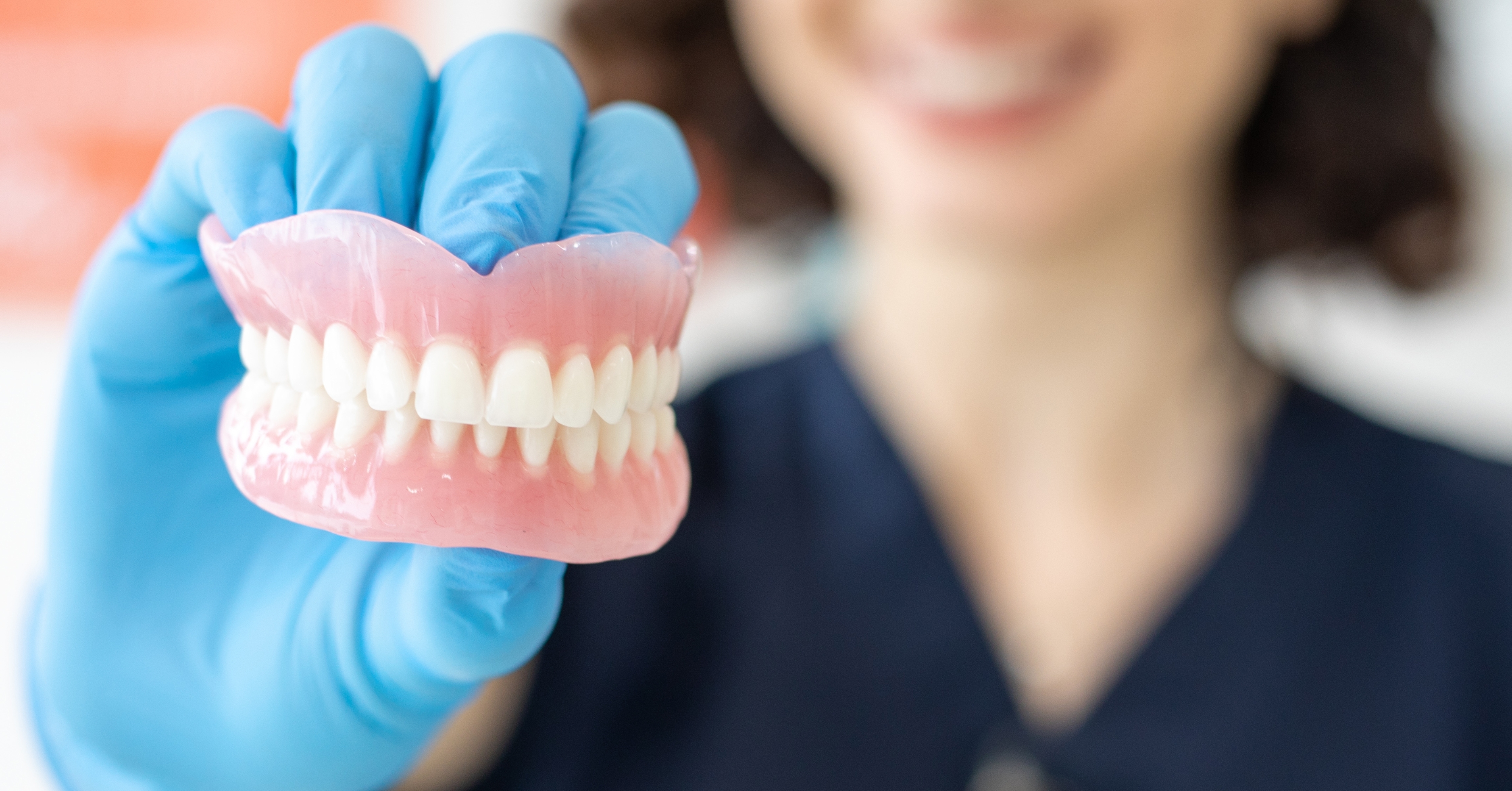 Dentist holding denture
