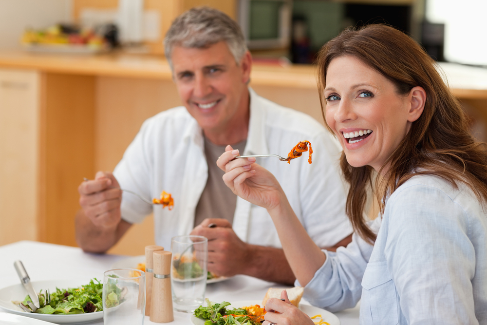 Laughing couple eating dinner together