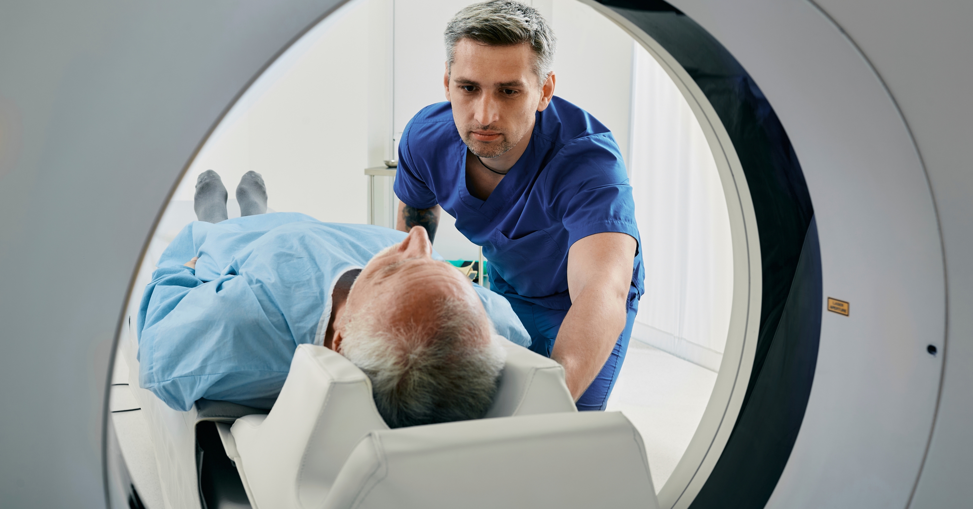 MRI technician guiding a patient into an MRI machine for a scan