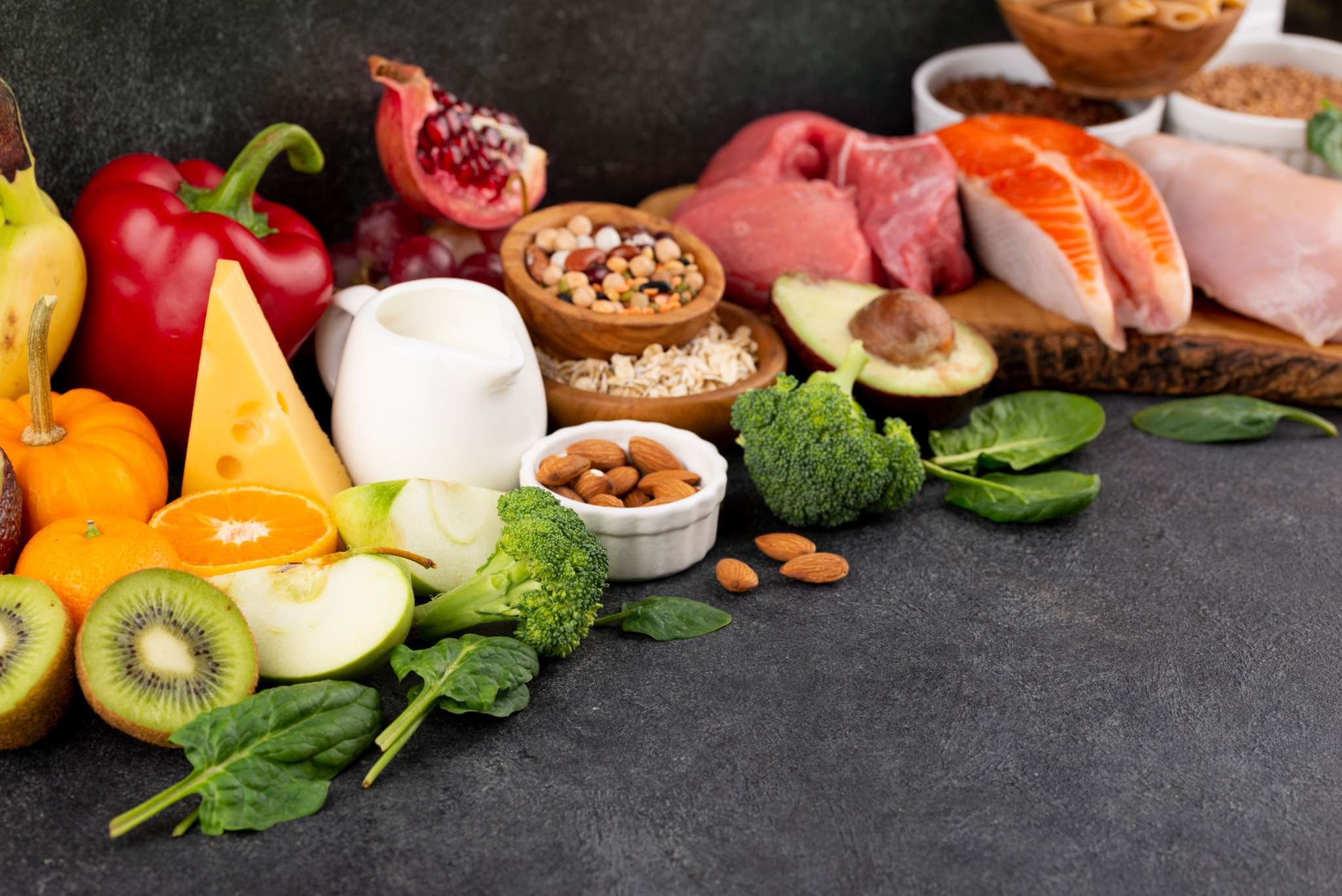 Fresh fruits, vegetables, nuts, and dairy displayed as healthy soft foods to eat after oral surgery.